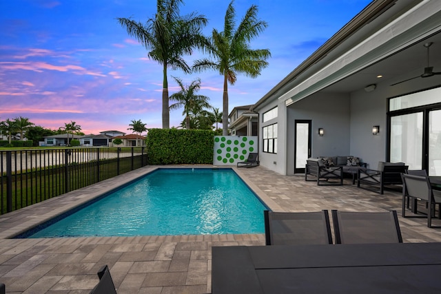pool at dusk featuring a fenced in pool, an outdoor living space, a fenced backyard, and a patio area