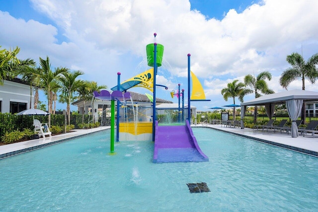 view of jungle gym with a water play area, a gazebo, a community pool, and fence