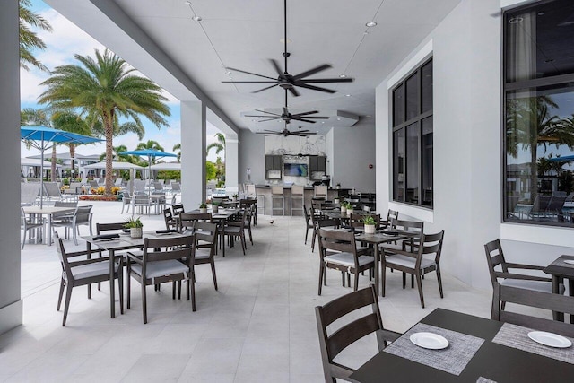 view of patio with outdoor dining area, outdoor dry bar, and ceiling fan
