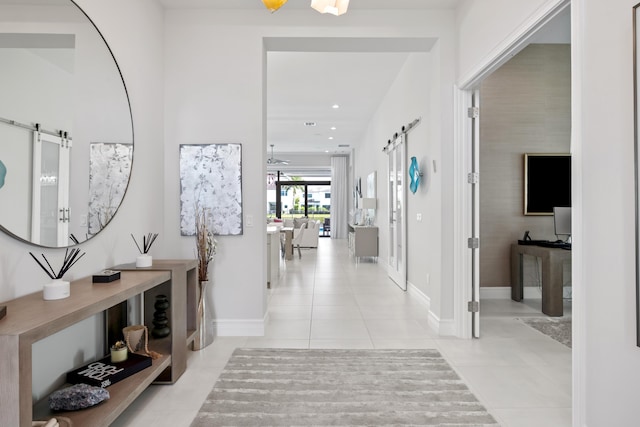 hall with recessed lighting, a barn door, baseboards, and light tile patterned floors
