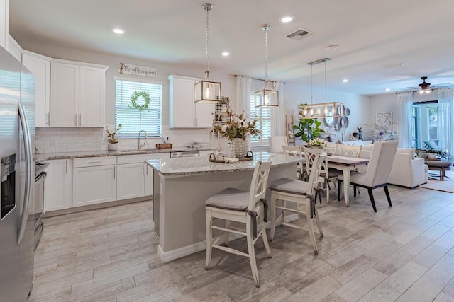 348 SE Courances Dr, Port Saint Lucie, FL 34984 - kitchen with stainless steel appliances, healthy amount of natural light, tasteful backsplash, light wood-style flooring, and recessed lighting