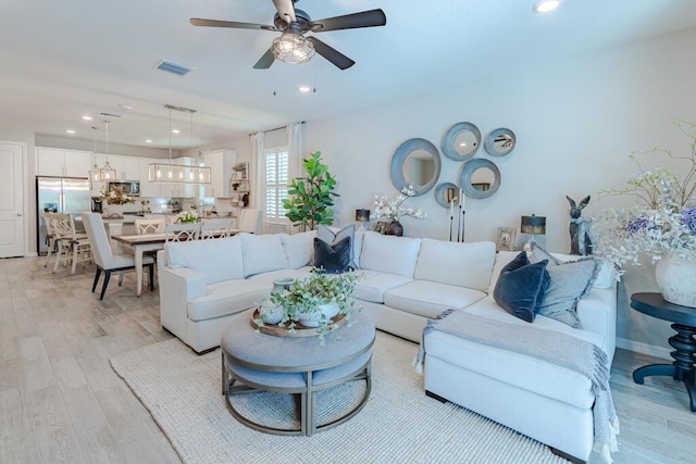 348 SE Courances Dr, Port Saint Lucie, FL 34984 - living room with light wood finished floors, a ceiling fan, recessed lighting, and a chandelier