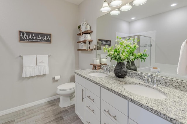 348 SE Courances Dr, Port Saint Lucie, FL 34984 - bathroom featuring a shower stall, double vanity, and wood finished floors
