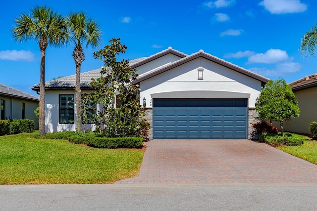 348 SE Courances Dr, Port Saint Lucie, FL 34984 - ranch-style home with stucco siding, a front yard, decorative driveway, a garage, and stone siding