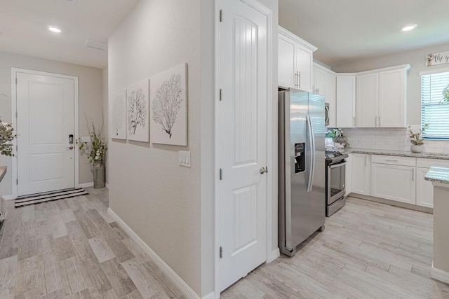 348 SE Courances Dr, Port Saint Lucie, FL 34984 - kitchen with stainless steel appliances, white cabinets, light stone counters, and recessed lighting