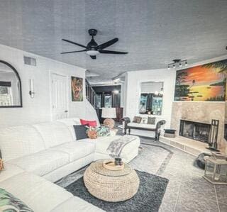 living area with a ceiling fan and a fireplace