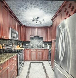 kitchen with stainless steel appliances, a notable chandelier, a textured ceiling, and backsplash