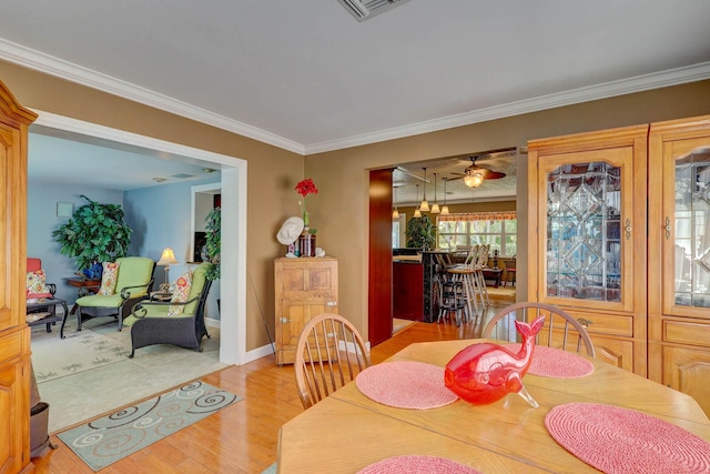 108 NE Carlisle Ln, Port Saint Lucie, FL 34952 - dining space featuring light wood-style floors, baseboards, ornamental molding, and visible vents