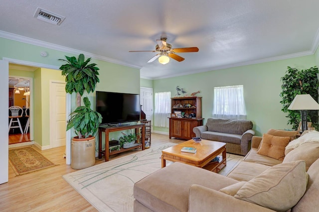 108 NE Carlisle Ln, Port Saint Lucie, FL 34952 - living room with crown molding, ceiling fan, visible vents, wood finished floors, and baseboards