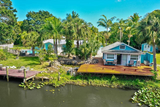 108 NE Carlisle Ln, Port Saint Lucie, FL 34952 - back of property with a yard and a deck with water view