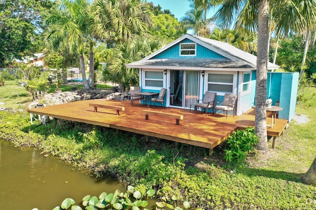 108 NE Carlisle Ln, Port Saint Lucie, FL 34952 - rear view of property with a wooden deck