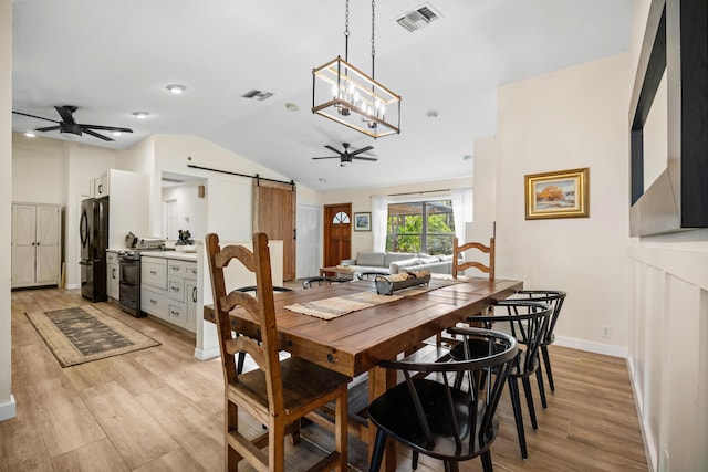 18292 126th Ter N, Jupiter, FL 33478 - dining area featuring a barn door, ceiling fan, light wood finished floors, lofted ceiling, and baseboards