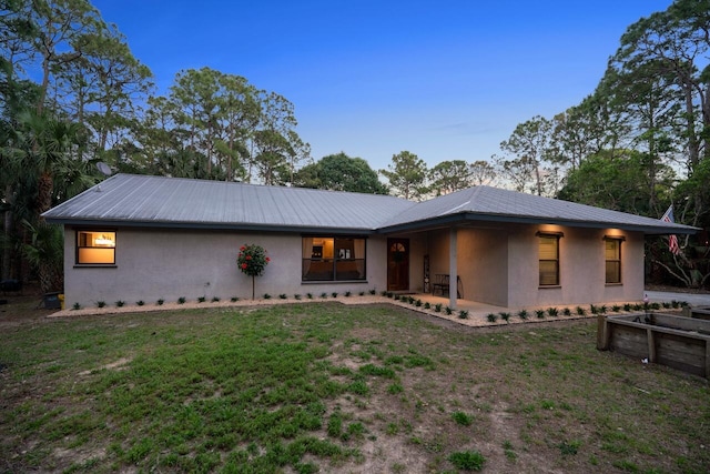 18292 126th Ter N, Jupiter, FL 33478 - view of front of property featuring stucco siding, metal roof, and a front lawn