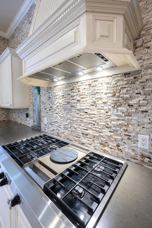 kitchen featuring range, premium range hood, crown molding, ornate columns, and decorative backsplash