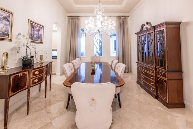 dining area featuring arched walkways, a tray ceiling, an inviting chandelier, and ornamental molding