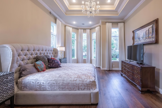 bedroom with crown molding, a raised ceiling, an inviting chandelier, and hardwood / wood-style flooring