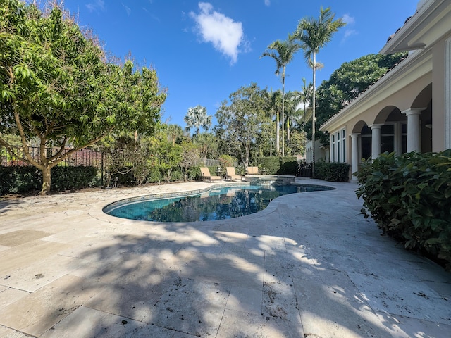 view of pool featuring a patio, a pool with connected hot tub, and a fenced backyard
