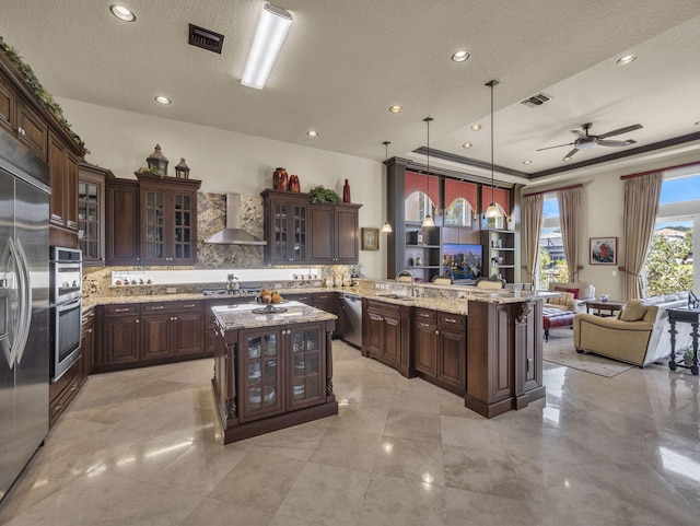 17384 Vistancia Cir, Boca Raton, FL 33496 - kitchen with visible vents, wall chimney exhaust hood, a sink, open floor plan, and a peninsula