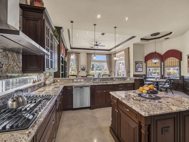 17384 Vistancia Cir, Boca Raton, FL 33496 - kitchen featuring wall chimney exhaust hood, a sink, appliances with stainless steel finishes, pendant lighting, and light stone counters