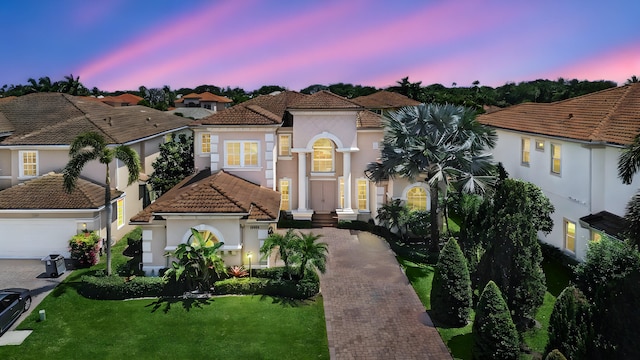 17384 Vistancia Cir, Boca Raton, FL 33496 - mediterranean / spanish-style house featuring a tiled roof, a lawn, stucco siding, and decorative driveway