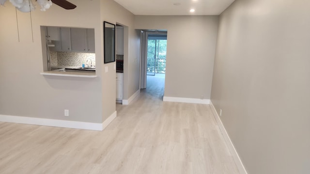 corridor with recessed lighting, light wood-style flooring, and baseboards