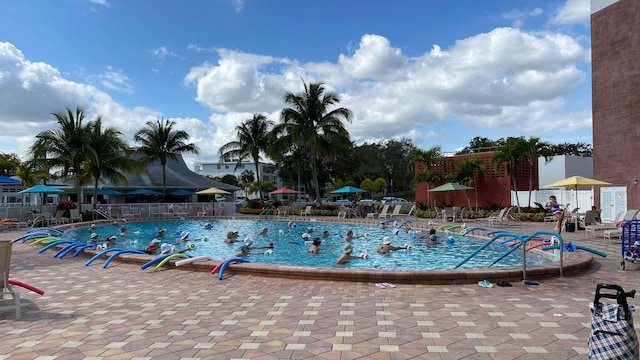 community pool with a patio and fence