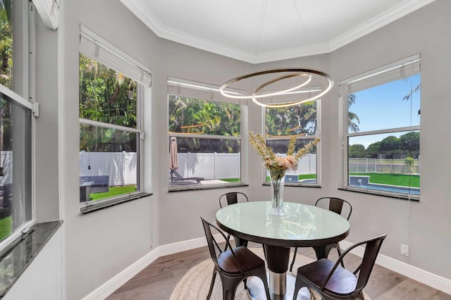 dining room featuring ornamental molding, baseboards, wood finished floors, and a chandelier