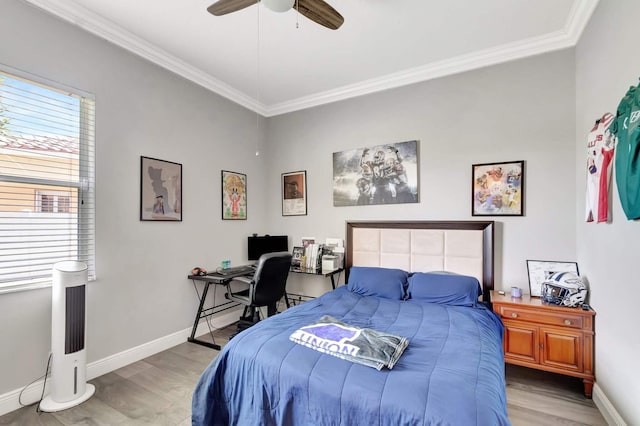 bedroom with wood finished floors, crown molding, baseboards, a ceiling fan, and a desk