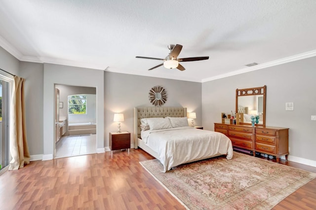 bedroom with light wood-style floors, crown molding, baseboards, a ceiling fan, and ensuite bath