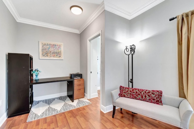 home office featuring light wood-type flooring, crown molding, and baseboards