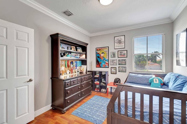 bedroom with light wood finished floors, ornamental molding, and baseboards