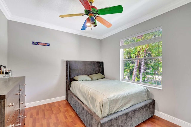bedroom featuring wood finished floors, baseboards, ornamental molding, and ceiling fan