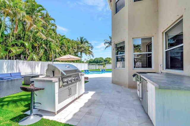 view of patio / terrace with grilling area, exterior kitchen, and a fenced backyard