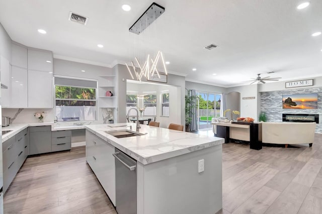 kitchen with modern cabinets, a sink, gray cabinets, ornamental molding, and recessed lighting