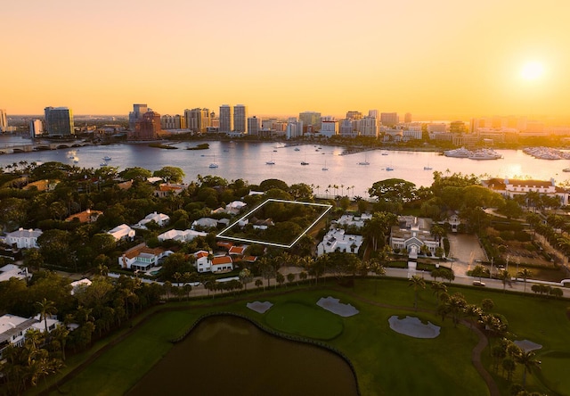 aerial view at dusk featuring a water view and a city view