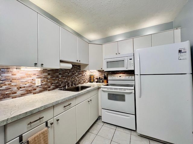 135 Dorchester F, West Palm Beach, FL 33417 - kitchen with light tile patterned floors, white appliances, tasteful backsplash, light countertops, and a sink