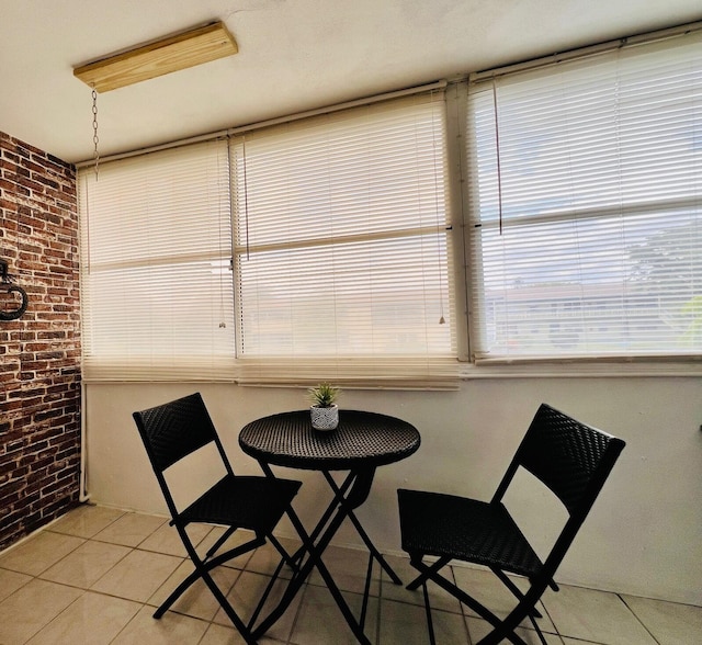 135 Dorchester F, West Palm Beach, FL 33417 - dining room featuring light tile patterned floors and brick wall