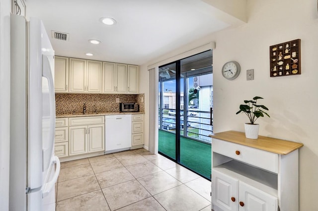 475 Piedmont J, Delray Beach, FL 33484 - kitchen featuring light tile patterned floors, white appliances, tasteful backsplash, visible vents, and a sink