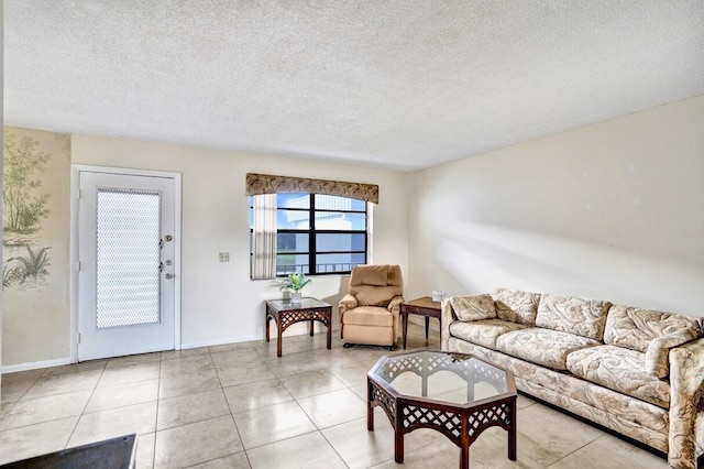 475 Piedmont J, Delray Beach, FL 33484 - living room with light tile patterned floors, a textured ceiling, and baseboards