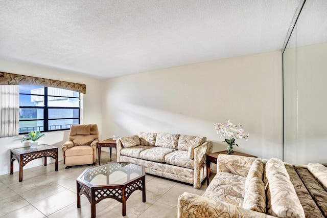 475 Piedmont J, Delray Beach, FL 33484 - living room featuring light tile patterned floors and a textured ceiling
