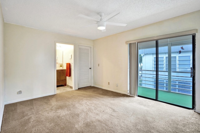 475 Piedmont J, Delray Beach, FL 33484 - unfurnished bedroom featuring baseboards, carpet flooring, ensuite bathroom, a textured ceiling, and access to exterior