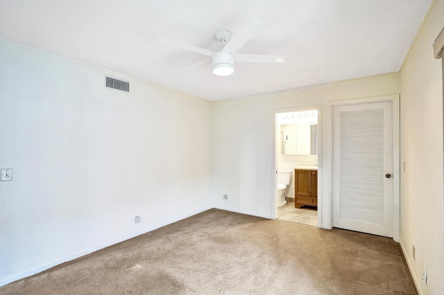475 Piedmont J, Delray Beach, FL 33484 - unfurnished bedroom featuring visible vents, baseboards, connected bathroom, and light carpet