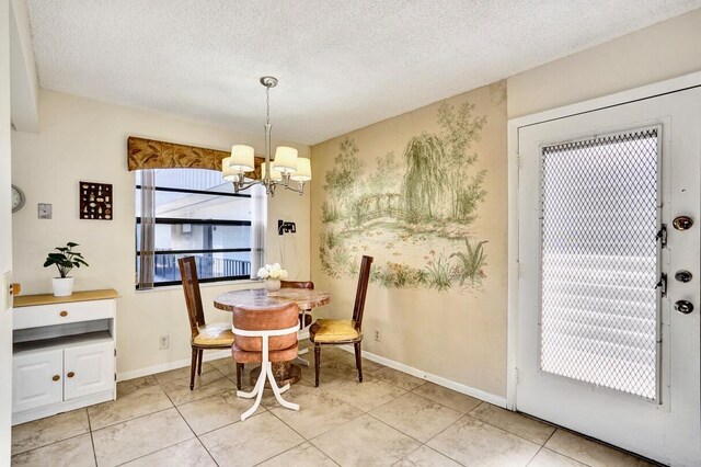 475 Piedmont J, Delray Beach, FL 33484 - dining area with light tile patterned flooring, a textured ceiling, an inviting chandelier, and baseboards