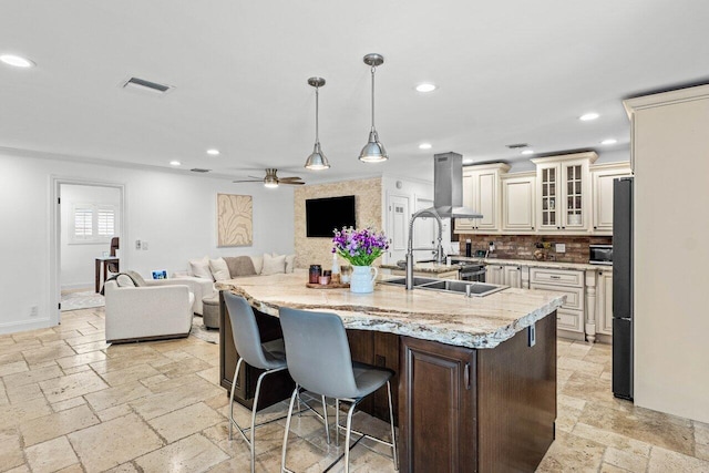 21786 Banyanwood Rd, Boca Raton, FL 33433 - kitchen with cream cabinets, stone tile floors, decorative backsplash, and a center island with sink