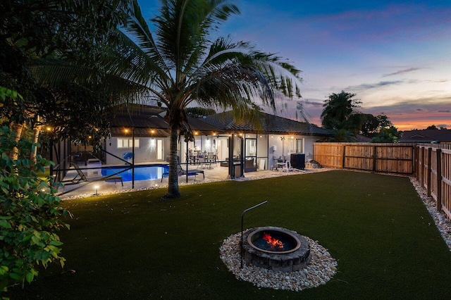 21786 Banyanwood Rd, Boca Raton, FL 33433 - back of property at dusk with cooling unit, a yard, a fenced backyard, and a patio area
