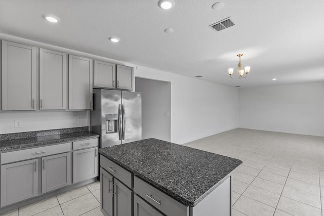 kitchen featuring stainless steel fridge with ice dispenser, gray cabinetry, and visible vents