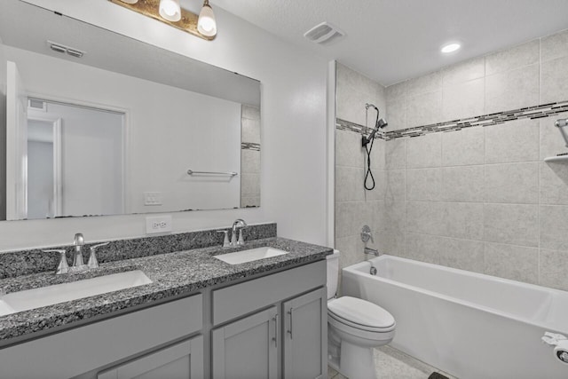 full bath featuring toilet, double vanity, a sink, and visible vents