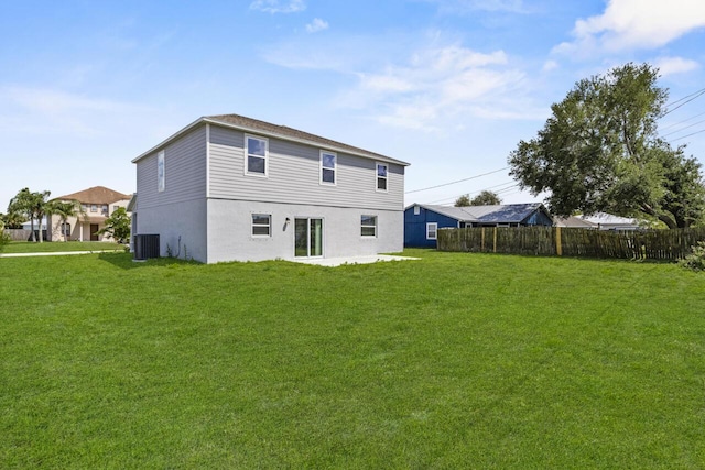 back of property featuring a yard, central AC, and fence