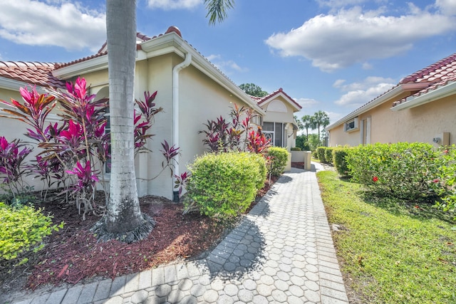 property entrance with a tiled roof and stucco siding