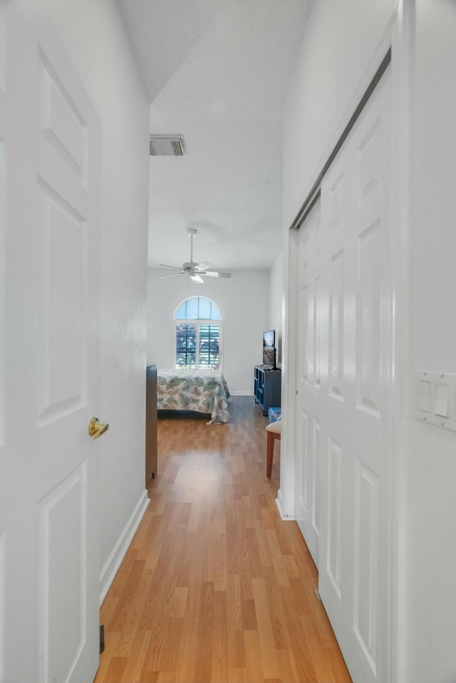 bedroom featuring ceiling fan, lofted ceiling, light wood-style floors, and baseboards
